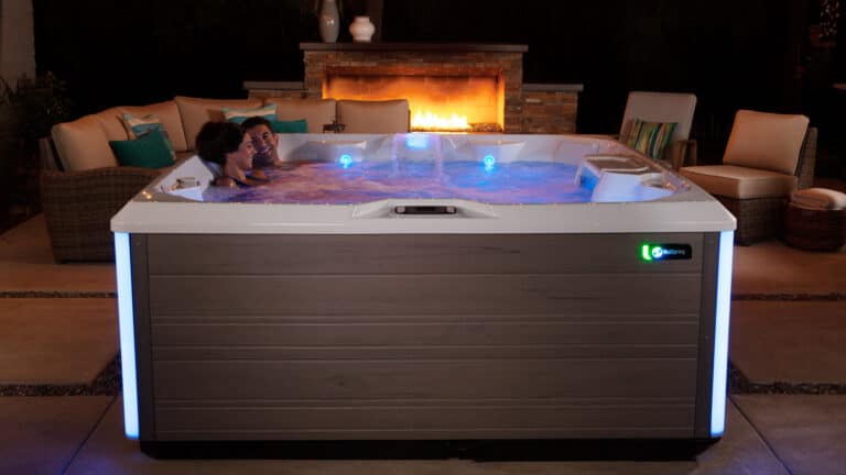 Whirlpool im Outdoor-Bereich bei Nacht mit farbiger LED-Beleuchtung und entspannter Nutzungsszene – HotSpring