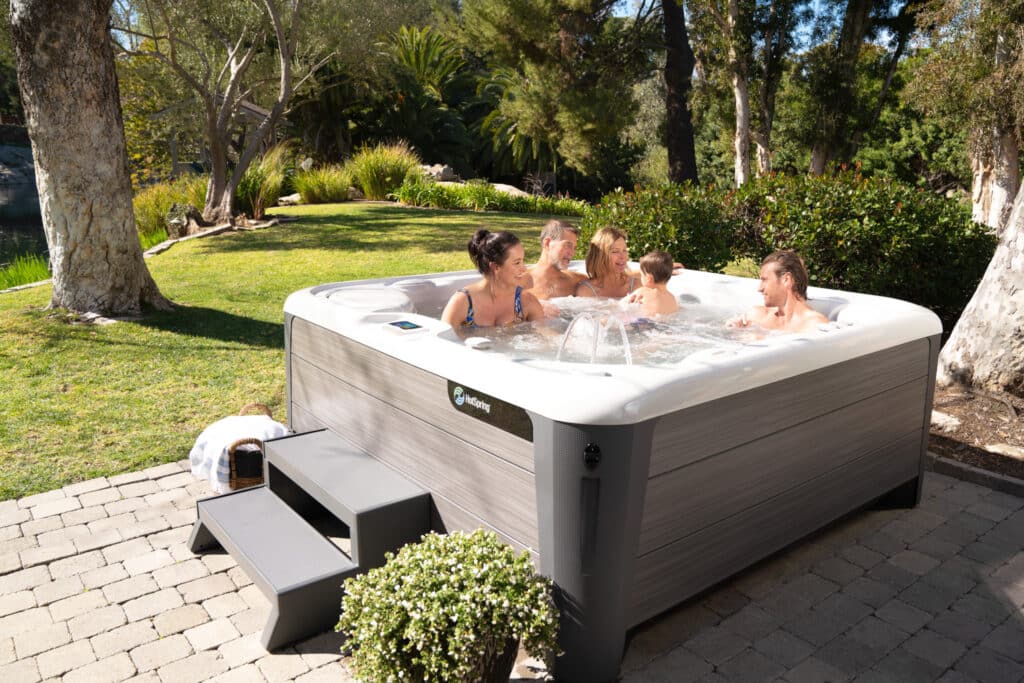 Whirlpool Lifestyle-Szene im Garten mit mehreren Personen in entspannter Familienrunde – HotSpring