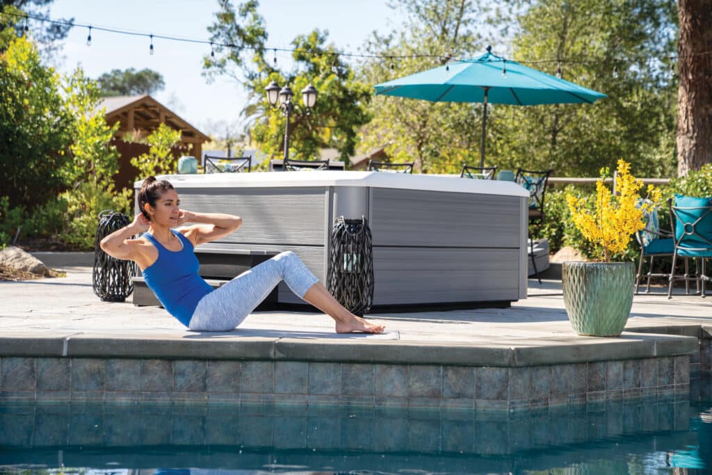 Whirlpool im Garten neben Poolbereich mit Person beim Outdoor-Workout – HotSpring
