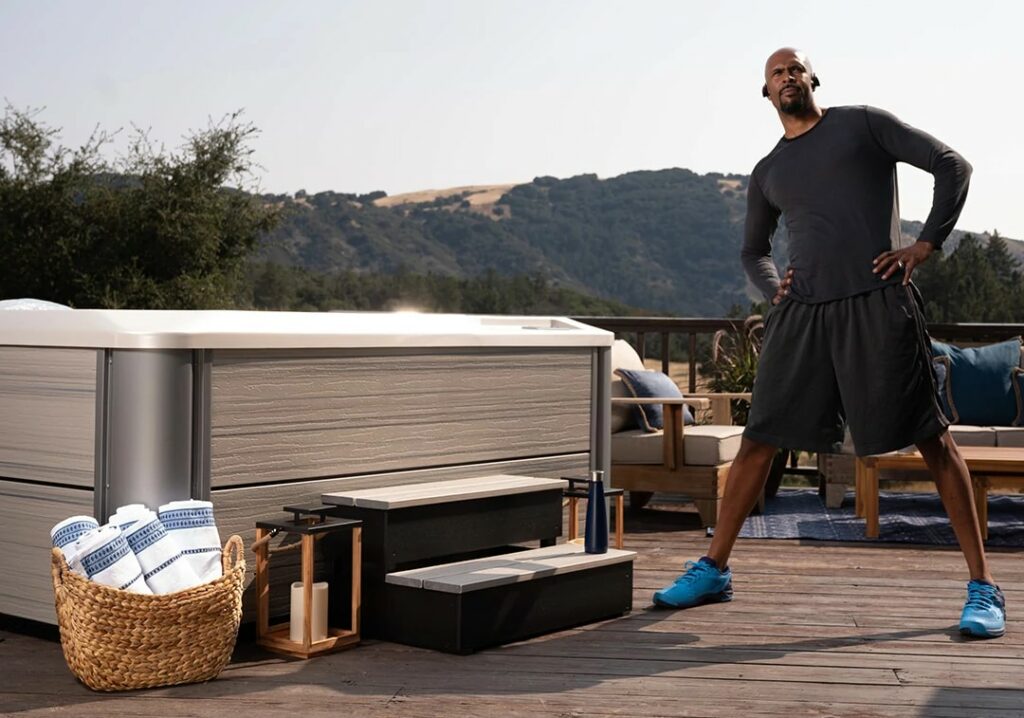 Whirlpool im Outdoor-Bereich mit Person bei Aufwärm-Übungen vor dem Training – HotSpring