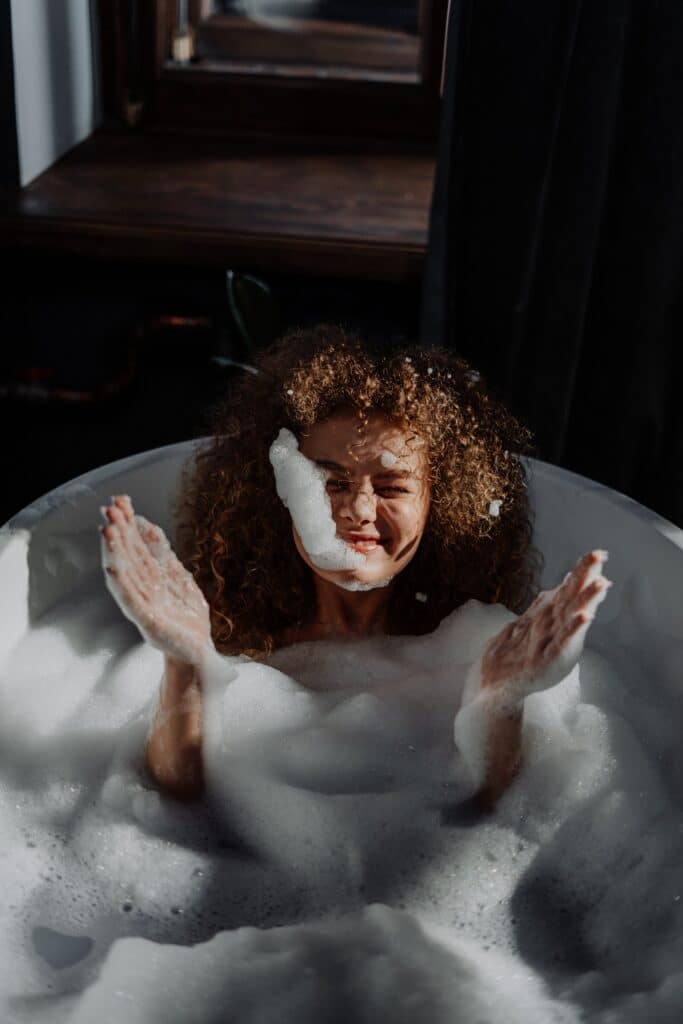 Person genießt ein warmes Schaumbad als Teil einer entspannenden Hydrotherapie-Routine – HotSpring