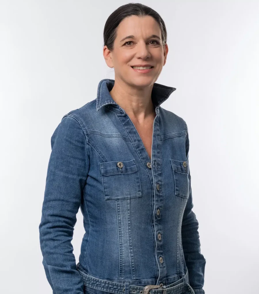 Frau in Jeanshemd lächelt in die Kamera – professionelles Porträtfoto für das HotSpring Team