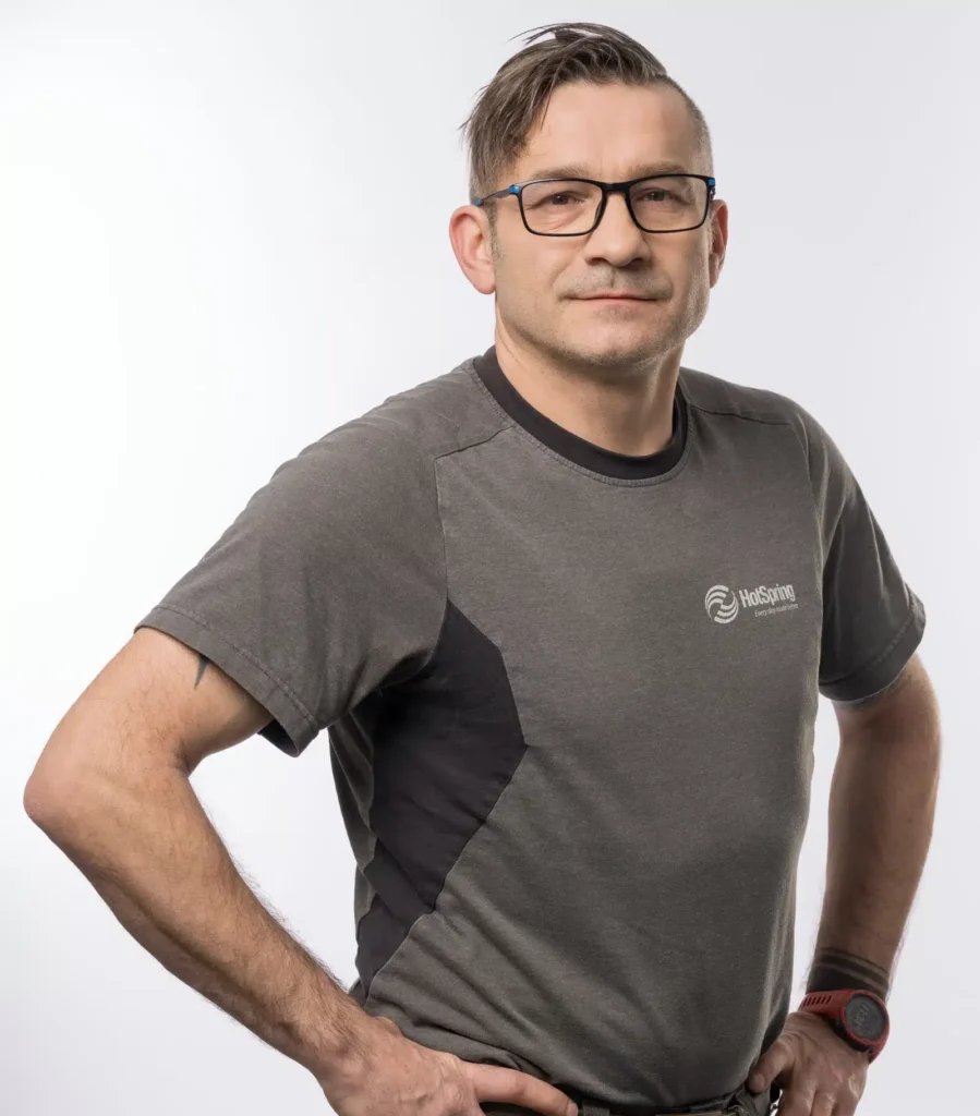 Mann in HotSpring Arbeitsshirt mit Brille – professionelles Porträtfoto für das HotSpring Team